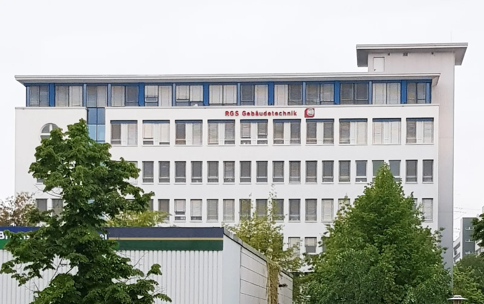 Mehrstöckiges weißes Bürohaus in Berlin mit der Aufschrift RGS Gebäudetechnik und Logo